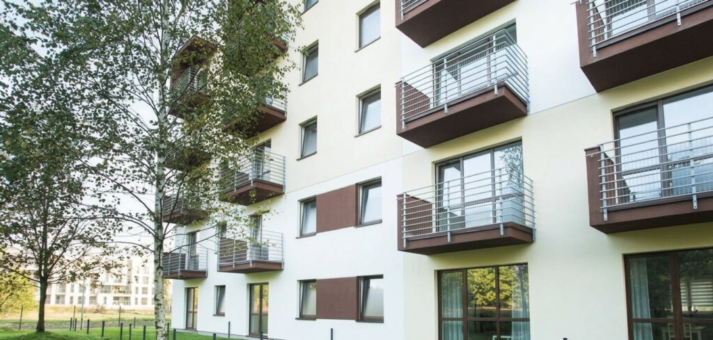 Mehrstöckiges Wohnhaus mit Balkonen und Bäumen im Vordergrund in Berg am Laim