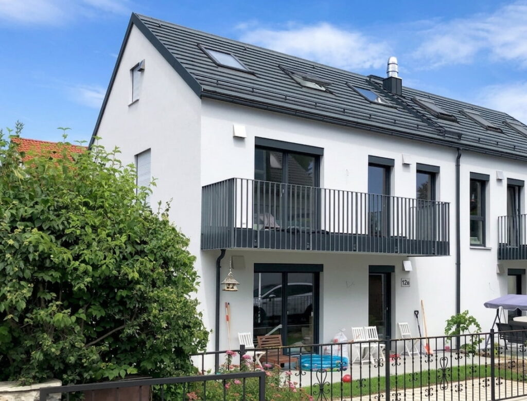 Zweistöckiges modernes Doppelhaus mit Balkon, Garten und Zaun in einem Wohngebiet