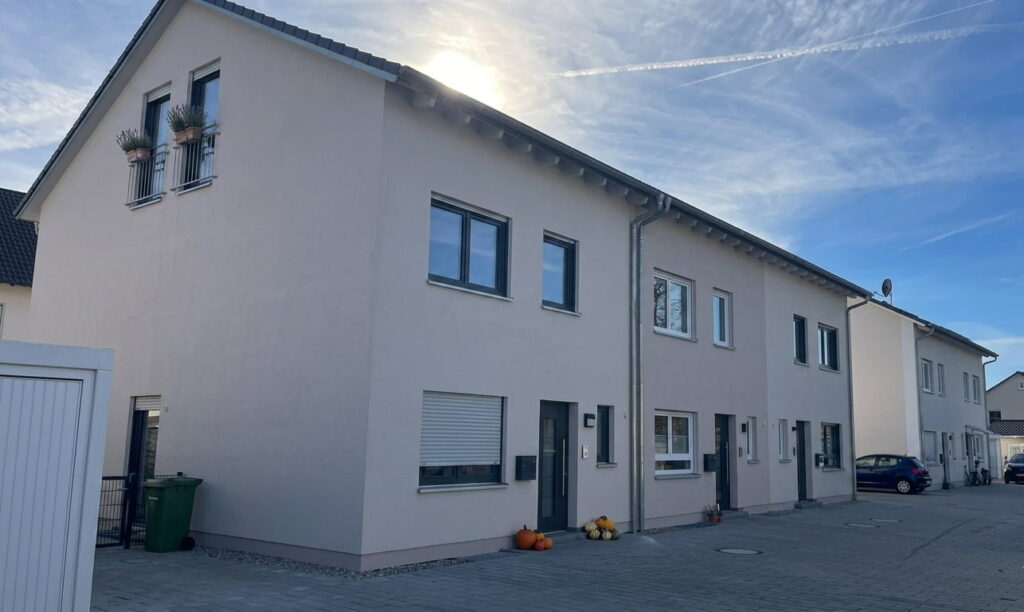 Reihenhaus mit mehreren Eingängen und Fenstern unter blauem Himmel in Milbertshofen