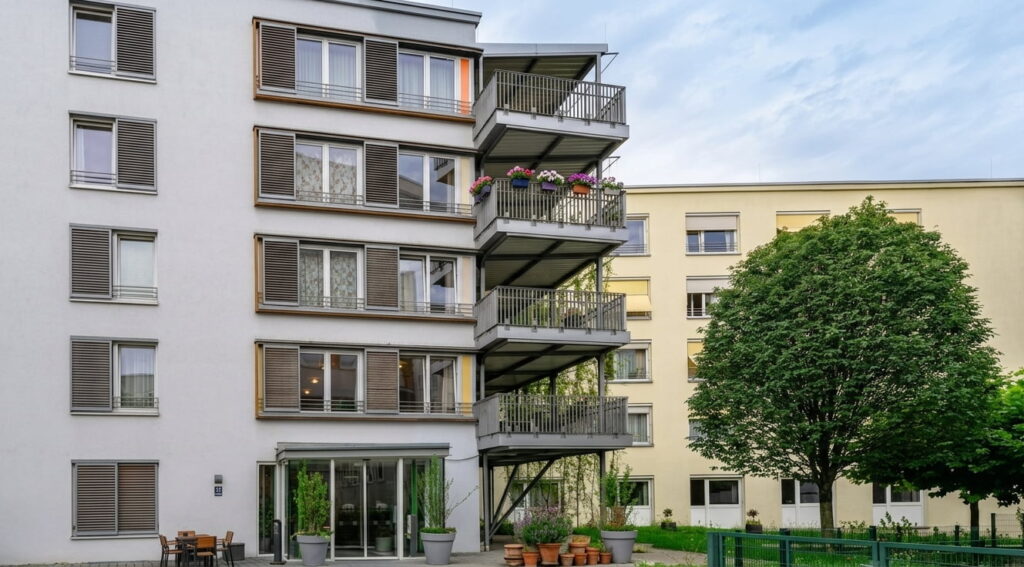 Mehrstöckiges Wohnhaus mit Balkonen und begrüntem Innenhof in Ramersdorf