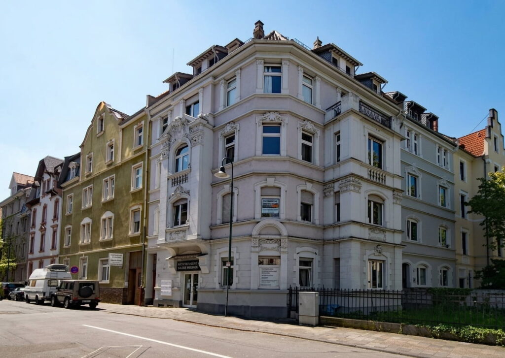 Straßenecke mit historischer mehrstöckiger Altbauimmobilie mit verzierten Fassadenelementen und mehreren Fenstern in einer Altstadt