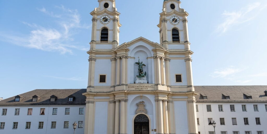 Barocke Kirche mit zwei Türmen und Uhr an der Fassade vor klarem Himmel