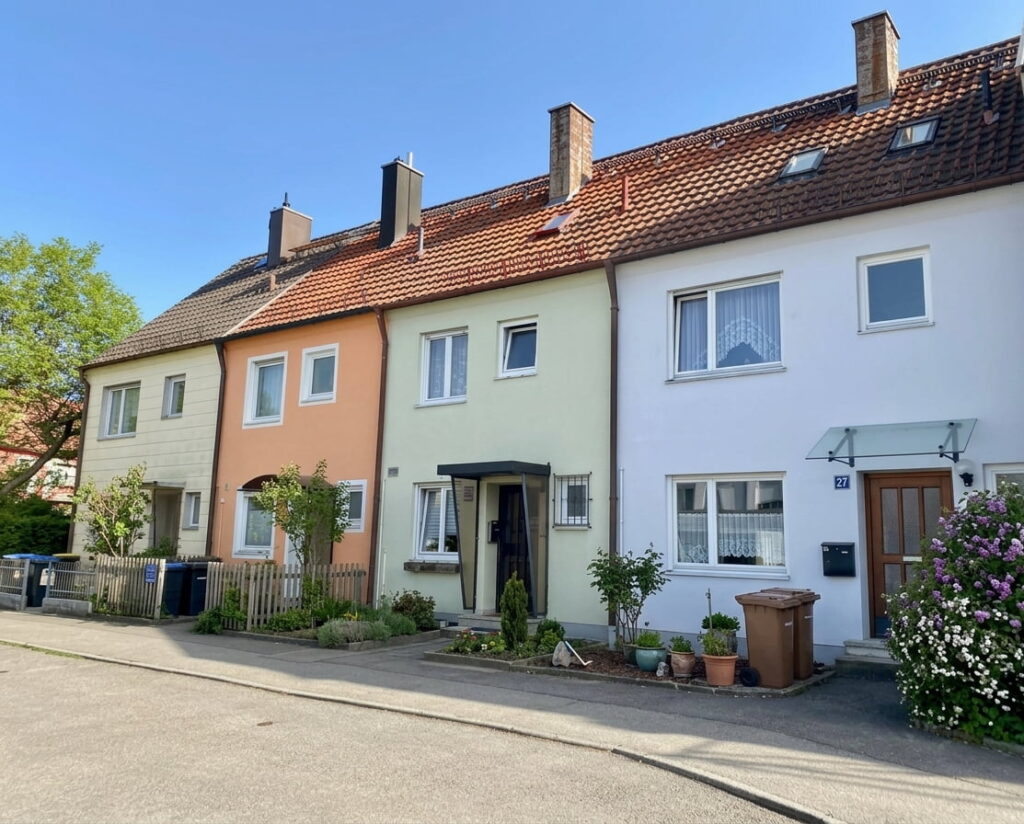 Reihe von zweistöckigen Reihenhäusern mit Satteldächern und kleinen Vorgärten in Ramersdorf