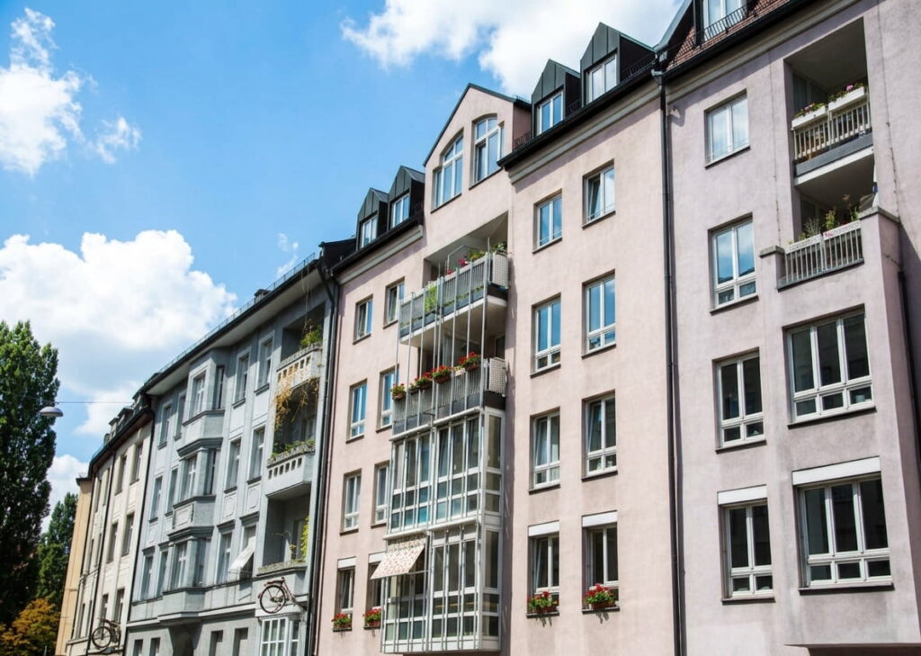 Mehrstöckige Wohngebäude mit Balkonen und großen Fenstern unter blauem Himmel in Schwabing