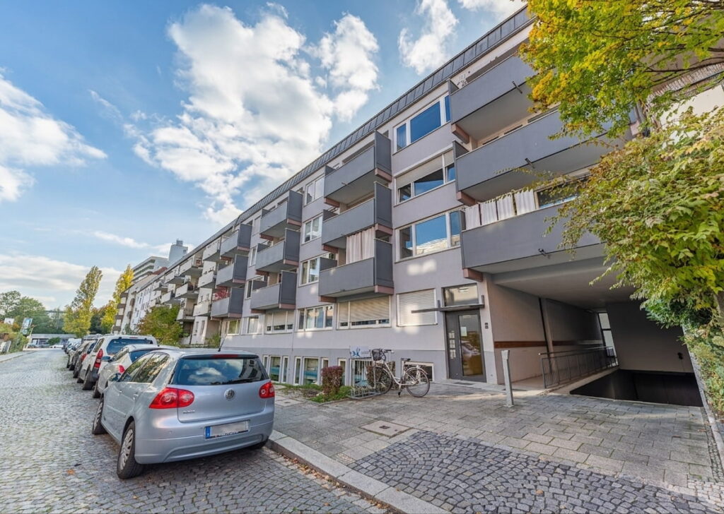Mehrstöckiges Wohngebäude mit Balkonen und Parkplätzen in einer ruhigen Straße in Sendling-Westpark