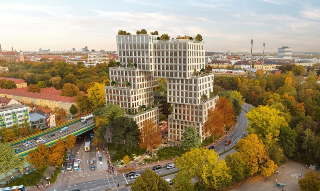 Mehrteiliger moderner Wohnkomplex mit begrünten Dachterrassen in einem herbstlich gefärbten Stadtgebiet mit Straßen und Bäumen in Untergiesing